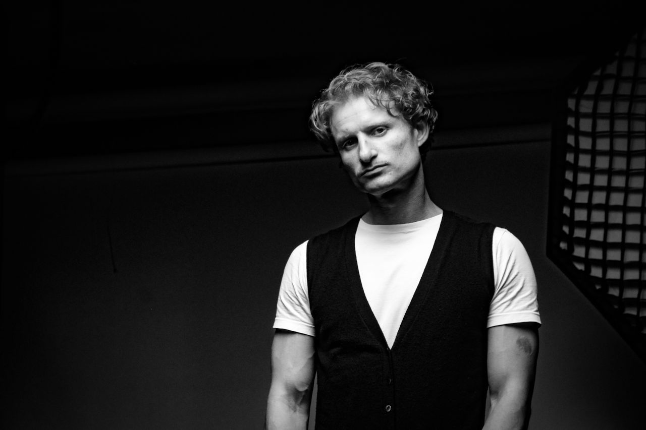 Black and white portrait of a man in studio lighting with a dramatic mood.