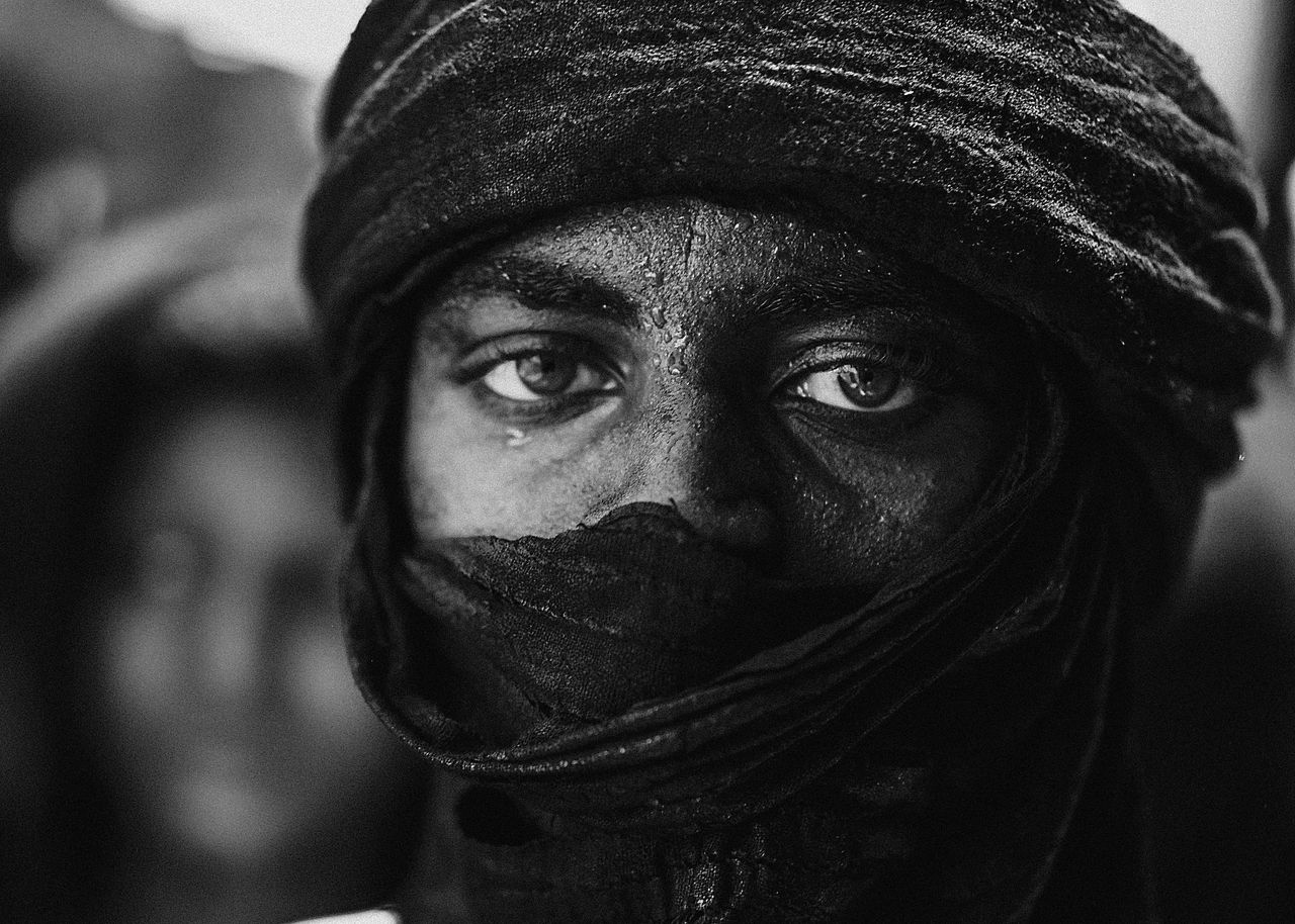 Intense black and white portrait of a man wearing a traditional scarf in Agadez, Niger.